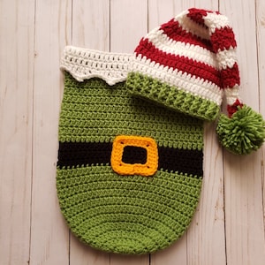 Puede incluir: Conjunto de disfraz de elfo tejido a mano, con un cuerpo verde con cinturón negro y hebilla amarilla, y un gorro a rayas rojo, blanco y verde a juego con un pompón verde. Diseñado para un bebé o un niño pequeño.