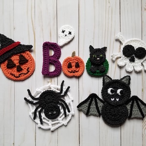 May include: A set of crocheted Halloween decorations, including a pumpkin, a ghost, a bat, a spider, a skull, a black cat, and the letter "B".