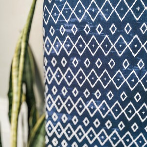 Pu&ograve; includere: Tessuto blu con un motivo geometrico a rombi bianchi.