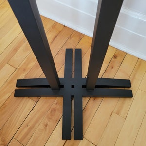 May include: Black metal table base with four legs and a cross-shaped support structure.