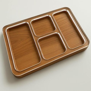 Puede incluir: Una bandeja de madera con cuatro compartimentos, cada uno con un borde plateado. La bandeja está hecha de madera marrón claro y tiene un acabado liso.