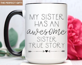 May include: White ceramic coffee mug with a black handle and black rim. The mug has black text that reads "My sister has an awesome sister. True story." with two arrows and a heart between the words "story" and "true".