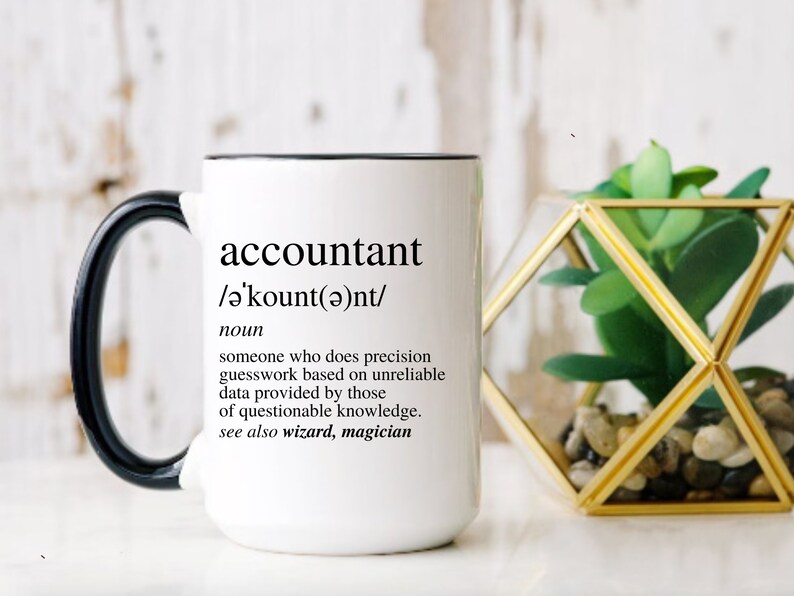 Op de afbeelding: Een witte keramische mok met een zwart handvat. De mok heeft een zwarte rand en de tekst "accountant /ə'kount(ə)nt/ noun someone who does precision guesswork based on unreliable data provided by those of questionable knowledge. see also wizard, magician" erop gedrukt.