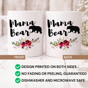 Puede incluir: Taza de cer&aacute;mica blanca con una silueta negra de una osa y su cachorro con el texto "Mama Bear" en letra negra. La taza tiene un dise&ntilde;o floral con flores rojas, rosas y blancas. La taza est&aacute; impresa en ambos lados.