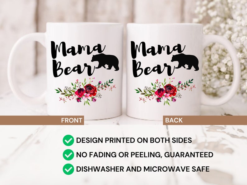 Puede incluir: Taza de cer&aacute;mica blanca con una silueta negra de una osa y su cachorro con el texto "Mama Bear" en letra negra. La taza tiene un dise&ntilde;o floral con flores rojas, rosas y blancas. La taza est&aacute; impresa en ambos lados.