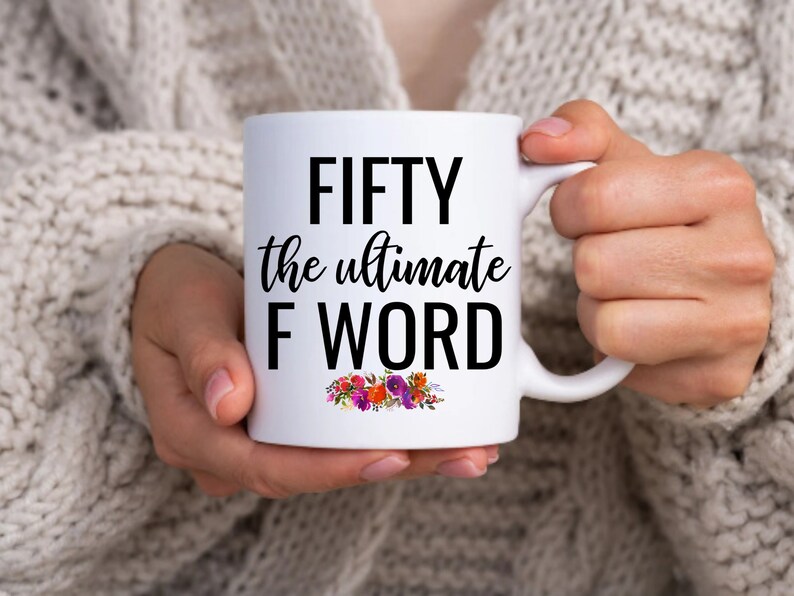 May include: White ceramic mug with black text that reads "FIFTY the ultimate F WORD" with a floral design at the bottom.