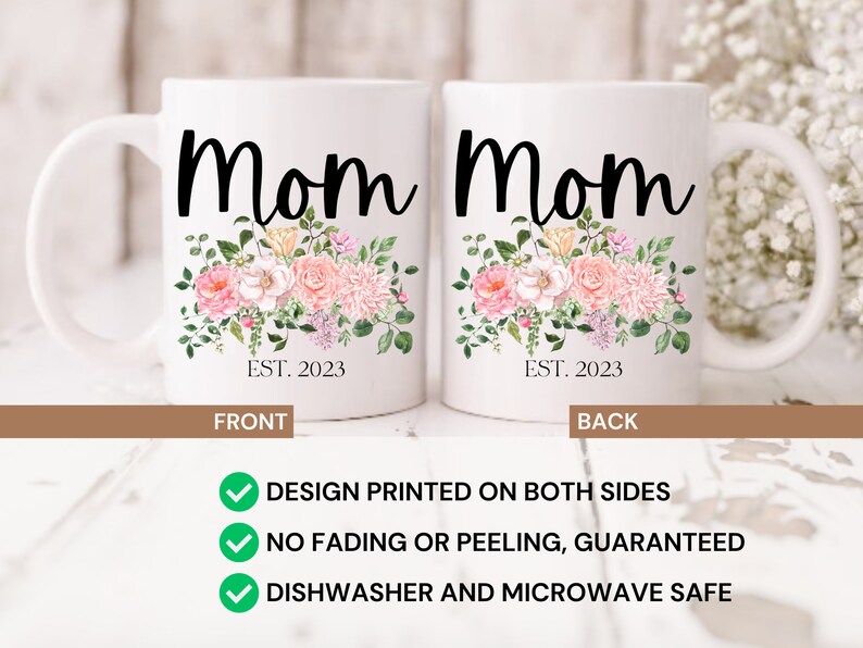 May include: White ceramic mug with a floral design and the word "Mom" printed in black. The text "EST. 2023" is printed below the floral design. The mug is shown from the front and back.