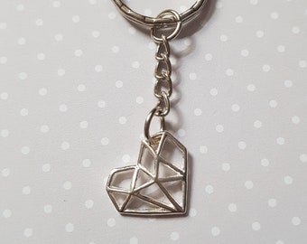 May include: A silver geometric heart keychain with a silver chain and a silver ring.