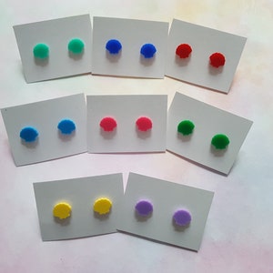 Peut inclure: Assortiment de boucles d'oreilles clous en forme de coquille de différentes couleurs, présentées sur des cartes blanches. Les boucles d'oreilles sont de couleur turquoise, bleu, rouge, rose, vert, jaune et violet.