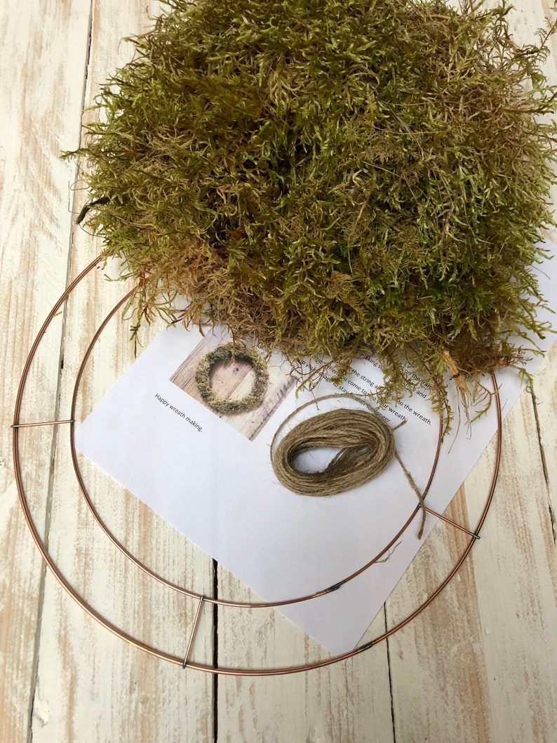 Pu&ograve; includere: Un kit fai-da-te per la creazione di ghirlande con un telaio in metallo color rame, muschio secco, spago e una guida stampata. Il muschio &egrave; un mix di verde e marrone. Il kit &egrave; su un fondo di legno bianco.