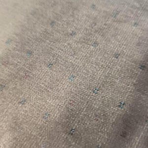 May include: A white ceramic mug with a black handle and the text "But First, Coffee" in a bold, black font. The mug is set against a blurred background, suggesting a cozy setting. The mug appears to be approximately 4 inches tall.