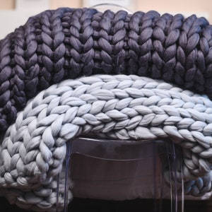 Super chunky knit blanket throw dark gray/gray/white/dusty rose/navy. Chunky yarn blanket usage. Big merino wool blanket in the interior. 
Color and size in the options.