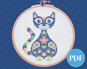 May include: A cross-stitch pattern of a black cat with a colorful floral design. The cat is sitting with its tail curled around its body. The pattern is in a wooden embroidery hoop.