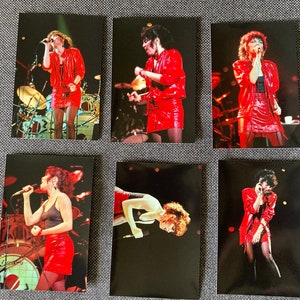 May include: Six black and white photographs of a woman singing on stage wearing a red leather jacket and skirt. The woman is holding a microphone in her hand.