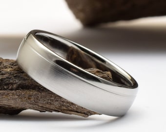 May include: A silver wedding band with a bevelled edge and a brushed finish.