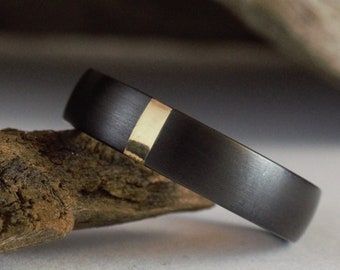 Moderne herentrouwring. Zwarte titanium ring met gouden inleg