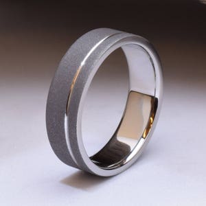 May include: A silver wedding band with a brushed finish and a polished edge.
