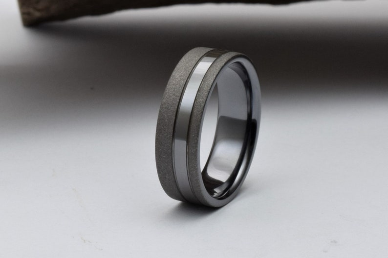 May include: A black and gray wedding band with a brushed finish and a polished groove.