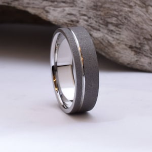 May include: A silver wedding band with a brushed finish and a polished groove.