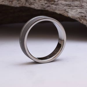 May include: A silver ring with a brushed finish and a polished edge.