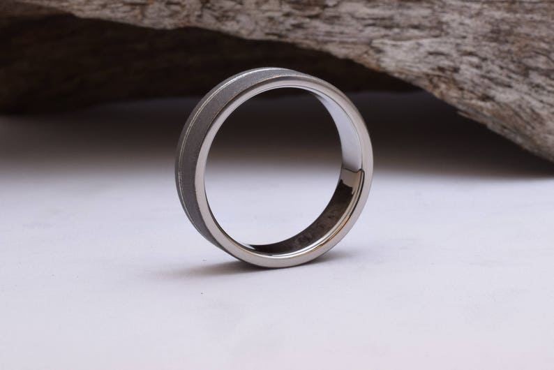 May include: A silver ring with a brushed finish and a polished edge.