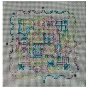 May include: A colorful cross-stitch pattern with a geometric design featuring squares, circles, and other shapes in shades of pink, blue, green, and purple.