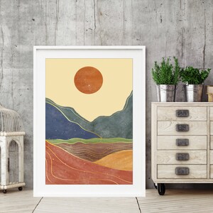 May include: Abstract landscape art print with a large orange sun, blue and green mountains, and gold lines on a beige background.