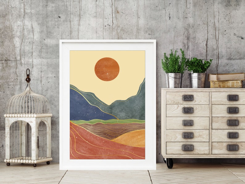 May include: Abstract landscape art print with a large orange sun, blue and green mountains, and gold lines on a beige background.