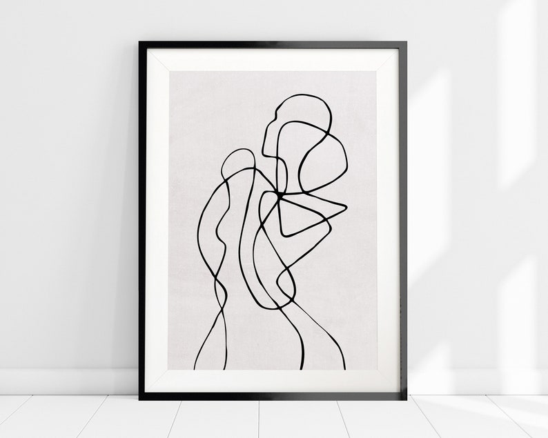 May include: Black and white abstract line art print in a black frame. The print features a series of curved lines that create a flowing, organic design.