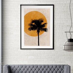 K&ouml;nnte beinhalten: Gerahmter Kunstdruck mit einer schwarzen Silhouette einer Palme vor einem gro&szlig;en orangefarbenen Kreis, der an einen Sonnenuntergang erinnert. Das Kunstwerk ist vor einem neutralen Hintergrund in einem schwarzen Rahmen pr&auml;sentiert.