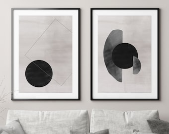 May include: Two framed abstract art prints with a minimalist design. The prints feature geometric shapes in black and white on a light gray background.