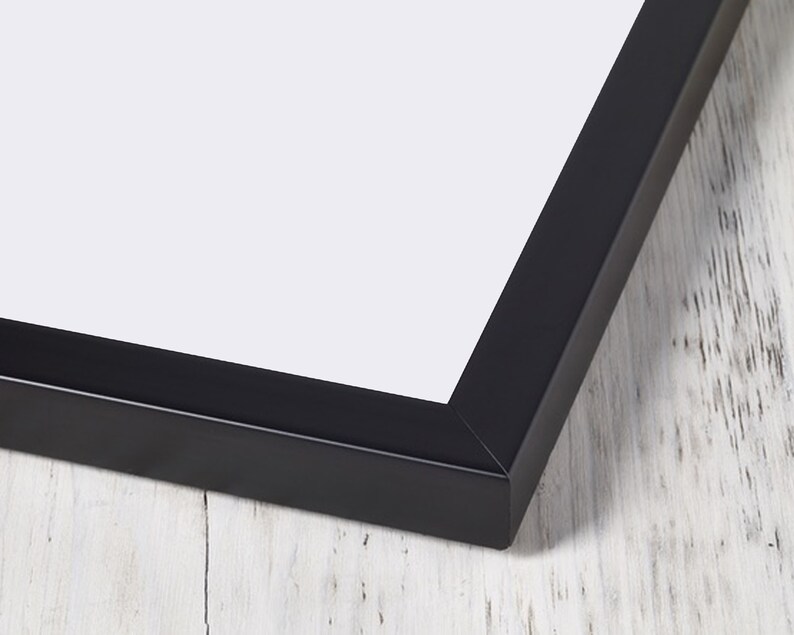 May include: Close-up of the corner of a black picture frame. The frame is made of wood and has a smooth finish.