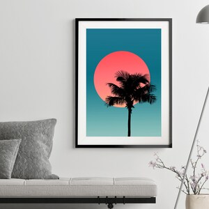 Pode incluir: Uma silhueta preta de uma palmeira fica em frente a um grande sol rosa e laranja contra um fundo degrad&ecirc; azul e verde.