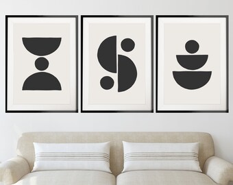 May include: Three black and white abstract geometric art prints in black frames. The prints feature different geometric shapes, including circles, semi-circles, and squares.