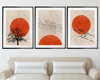 May include: Three framed prints with a minimalist design. Each print features a large orange circle and a black silhouette. The left print shows a tree, the middle print shows a flock of birds, and the right print shows a flock of birds flying around the orange circle.