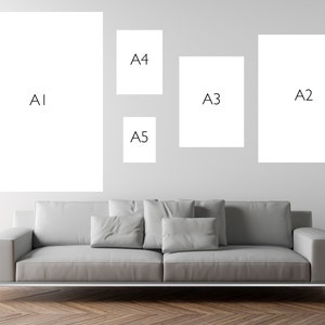 May include: A white wall with five different sized white frames. The frames are labeled A1, A2, A3, A4, and A5. A gray couch is in front of the wall.
