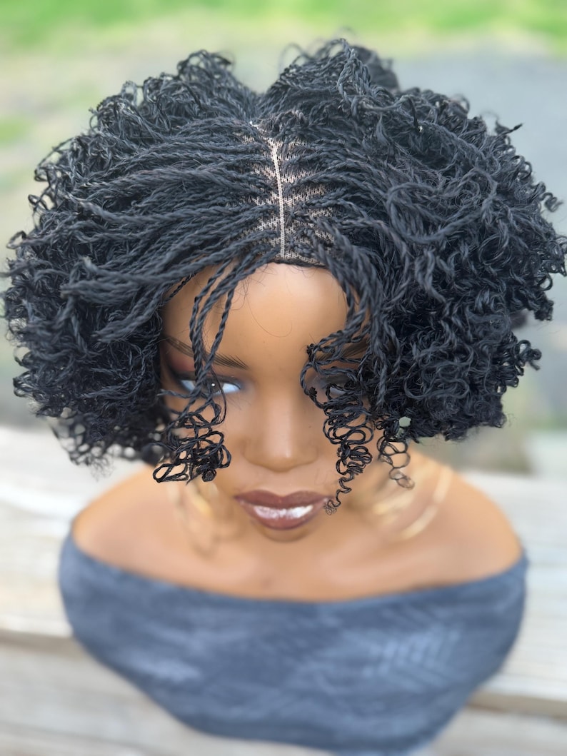 May include: A black micro-braided wig with a natural-looking hairline. The wig features small, tightly woven braids that create a textured, voluminous style. The wig is styled on a mannequin head, showcasing the intricate braiding pattern and overall aesthetic.