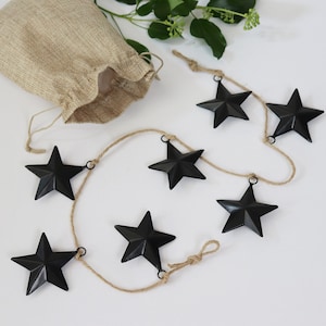 Black metal stars with hanging loop and twine. We'll enclose a small hessian bag to store the stars.