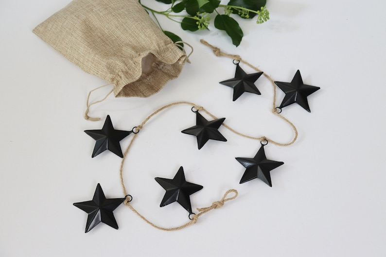 Black metal stars with hanging loop and twine. We'll enclose a small hessian bag to store the stars.