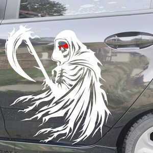 May include: White vinyl decal of the Grim Reaper with a scythe, applied to a car door. The Grim Reaper has red eyes and is wearing a hooded cloak. The decal is a detailed, stylized illustration.