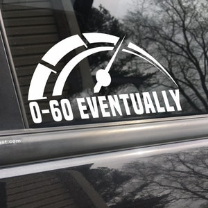 May include: White vinyl decal of a speedometer with a needle pointing to the red zone and the text "0-60 EVENTUALLY".