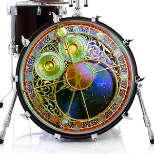 Op de afbeelding: Een basdrum met een gouden en blauw ontwerp met een klok met Romeinse cijfers en een sterrenbeeldpatroon. De drum staat op een witte achtergrond.