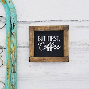 Puede incluir: Un letrero de madera rústico con fondo negro y texto blanco que dice "But First, Coffee".
