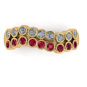 Puede incluir: Un anillo de banda de oro con una doble fila de piedras preciosas engastadas en bisel. La fila superior presenta diamantes redondos transparentes y la fila inferior presenta rubíes redondos rojos.