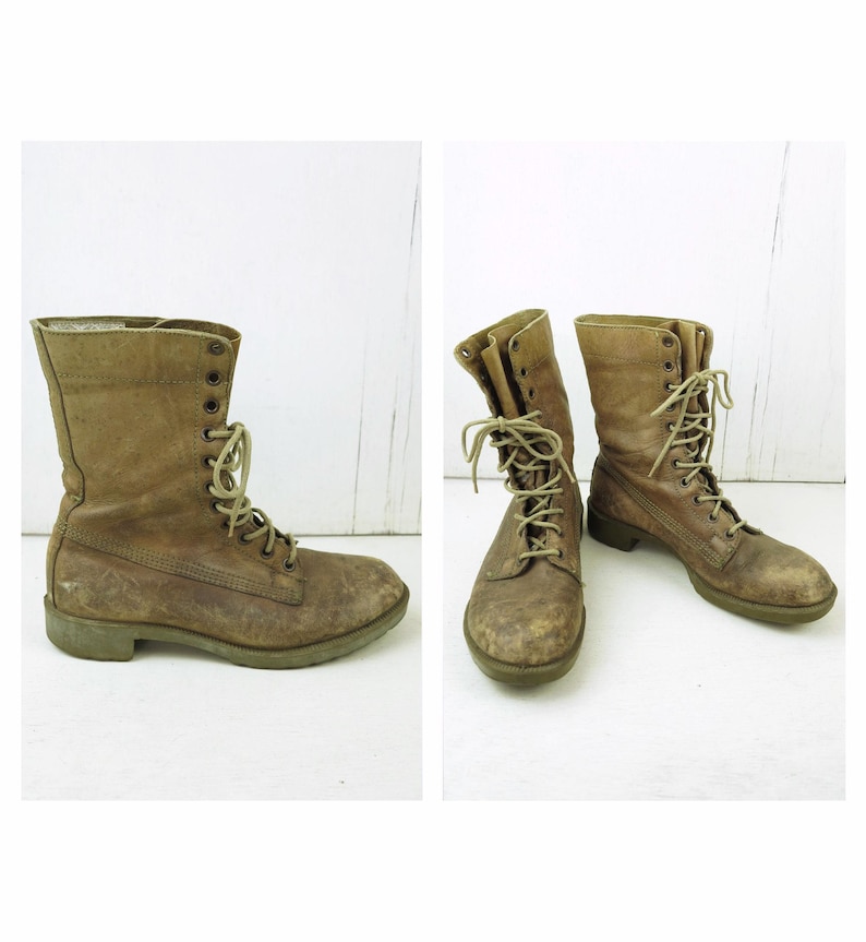 May include: Two brown leather combat boots with laces. The boots are worn and have a distressed appearance. The laces are a lighter shade of brown. The boots are on a white surface.