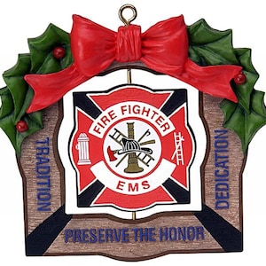 May include: A red, white, and blue Christmas ornament with a fire fighter emblem. The ornament is shaped like a shield with the words "Fire Fighter" in a circle around a fire fighter helmet and axe. The words "Tradition", "Dedication", and "Preserve the Honor" are on the ornament.
