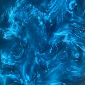 May include: Abstract blue and white swirling pattern with a glittery finish. The pattern resembles a galaxy or nebula.