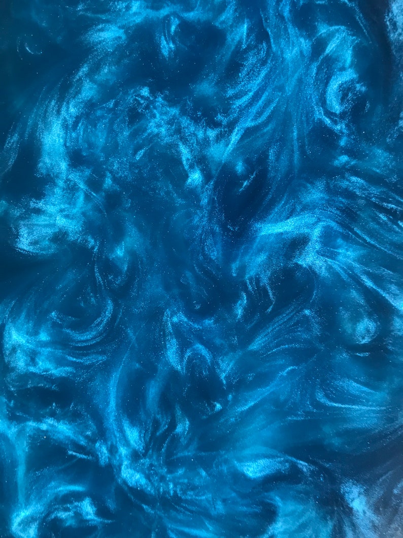 May include: Abstract blue and white swirling pattern with a glittery finish. The pattern resembles a galaxy or nebula.