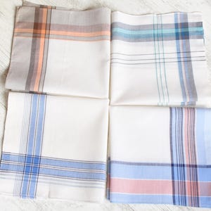 May include: Four white cotton handkerchiefs with different plaid patterns. The handkerchiefs have blue, pink, and orange stripes.