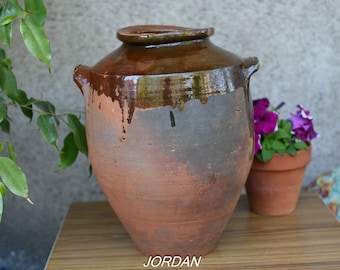 大きな陶器の土鍋。蓋と 2 つの取っ手が付いた土鍋。素朴な田舎